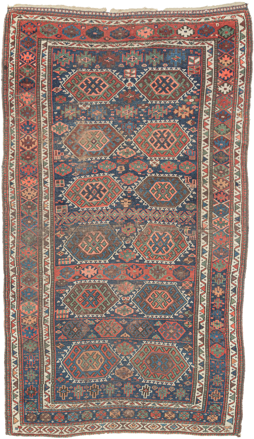 SANJABI KURD features a field of graphic hexagons filled with stylized protection symbols in rich tones of blues, reds, greens, coral, aubergine, gold, brown and ivory on a lively indigo ground. Each pair of hexagons is separated by bands of geometric shapes added in perfectly imperfect asymmetric fashion giving the composition a dynamic visual rhythm while the vibrant borders add welcomed balance and refinement. If you look closely you will find the inclusion of two camel like figures