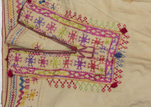This Blouse was crafted in Afghanistan by the Hazara during the 20th century.
The Hazara are a distinct and often persecuted ethnic group that primarily live in Central Afghanistan and comprise a majority of the country's Shi'ite population. This blouse was embroidered in vibrant red, pink, purple, green and yellow silk on cotton. This embroidery style and design lexicon are classic Hazara production that can also be seen in well-known torba cloths.