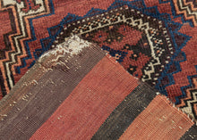 This Baluch rug was handwoven during the early 20th century in Afghanistan.
It features two octagonal Turkmen guls on a red ground and framed by a border of hourglass and cruciform shapes. Rich saturated tones and nice interplay between light and dark. It has original kilim ends on top and bottom that are each embellished with their own weft float pattern. This balisht has it's original kilim back still intact and which employs thick stripes of red, orange, brown and ivory.