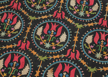 This embroidered textile is a well-preserved example of late Ottoman Armenian domestic needlework, likely produced in the town of Marash (modern-day Kahramanmaraş, Turkey) at the turn of the 20th century.  
The embroidery is executed in silk floss using satin and couching stitches across a black cotton ground.  It features concentric floral medallions, stylized birds and serrated leaves in lively blues, greens, red, pink, purple, yellow and ivory. Notably, two guardian-like anthropomorphic figure