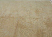 This Tibetan rug was woven during the late 20th century by Tibetan weavers in the Kathmandu Valley of Nepal for the Tufenkian Studio.
It is rendered in a tranquil tone-on-tone palette of warm golds, beiges, and soft dusty pink. The the rug features a subtle relief pattern of leafy vines and gentle wave motifs that are achieved through masterful carving and pile manipulation.The composition strikes a quiet harmony between texture and tone, allowing natural light to animate the surface with understated elega