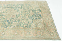It features an ornate all-over design of muted palmettes and floral sprays in various soft shades of caramel, khaki and terracotta on an undulating indigo ground. It is framed by a border of alternating palmettes on meandering vines on a dusty peach ground. Very decorative, a soft, and elegant piece that will subtly elevate any space. washed out tabriz