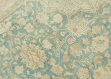 It features an ornate all-over design of muted palmettes and floral sprays in various soft shades of caramel, khaki and terracotta on an undulating indigo ground. It is framed by a border of alternating palmettes on meandering vines on a dusty peach ground. Very decorative, a soft, and elegant piece that will subtly elevate any space. washed out tabriz