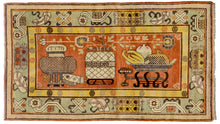 Depiction of a bowl of fruit, a flower filled vase and various other auspicious symbols on a rich terracotta ground. The terracotta is nicely balanced by a but patinated celadon ground main border and a canary yellow ground minor border of repeating shou symbols. Shou is a very auspicious symbol that represents longevity. These rugs are often referred as "Samarkand" rugs as Samarkand was at one time the major gathering point for the rugs woven in Northwest China.