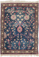 This Mohajeran Sarouk was handwoven during the first quarter of the 20th century. 
It features an imaginative tree of life design of a small cypress flanked by two whimsically intersecting trees bearing palmette-shaped "fruit" on an inky blue ground. . Plush and well-executed these best-of-type Sarouks are referred to as "Mohajeran". Thinly framed like a painting with a generously spaced floral main border flanked by minor borders of polychrome circles;This classically patterned rug should