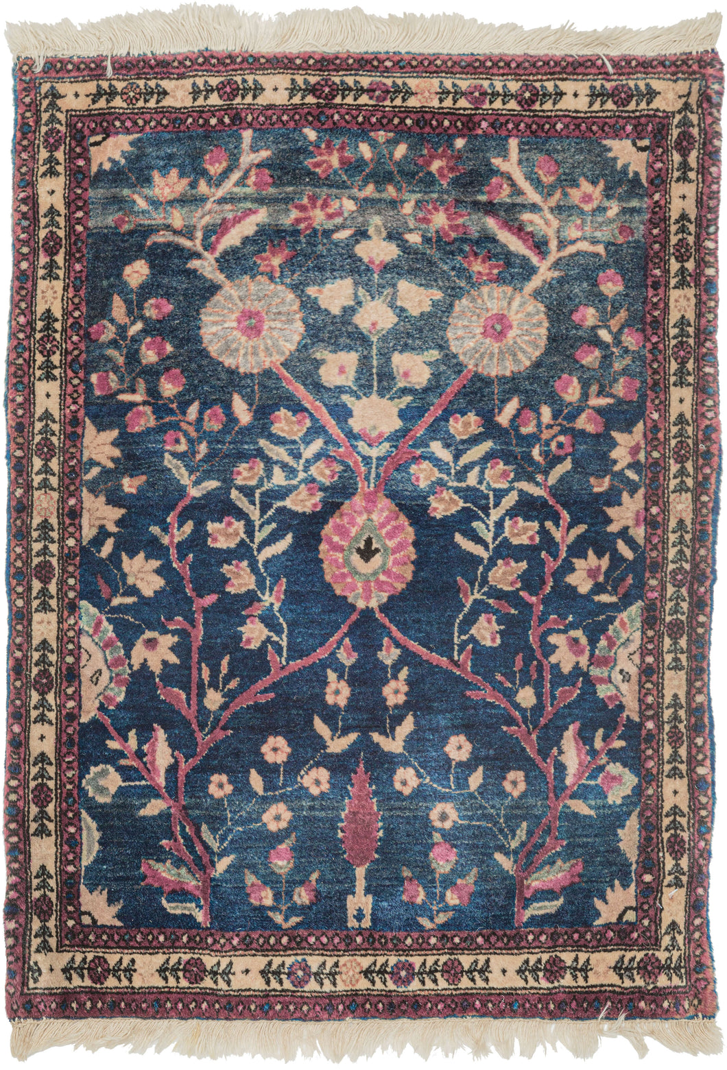 This Mohajeran Sarouk was handwoven during the first quarter of the 20th century. 
It features an imaginative tree of life design of a small cypress flanked by two whimsically intersecting trees bearing palmette-shaped