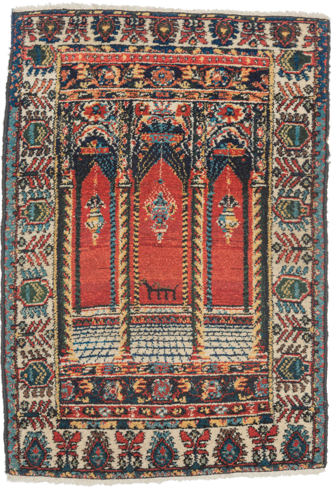 This Senneh rug was woven during the second quarter of the 20th Century.
Wonderful but still folky perspective of looking into a building with three arches each with a hanging lantern. The perspective is accentuated by a grid which runs into a columned platform before breaking off into the glowing red distance. The piece is further differentiated by the addition of a zoomorphic alter directly in the center.