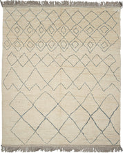 This Moroccan-styled rug was woven during the 21st century in Afghanistan.  It features an idiosyncratic pattern of diamond lattices. that have the feel of pencil quickly scribbled on paper. A simple palette of soft bluish gray lines which almost appear scribbled upon the shaggy cream ground. Woven of hearty, hand-spun Afghan wool giving it durability and extra heft not commonly found in the Moroccan weaving usually associated with this patterning.