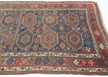 SANJABI KURD features a field of graphic hexagons filled with stylized protection symbols in rich tones of blues, reds, greens, coral, aubergine, gold, brown and ivory on a lively indigo ground. Each pair of hexagons is separated by bands of geometric shapes added in perfectly imperfect asymmetric fashion giving the composition a dynamic visual rhythm while the vibrant borders add welcomed balance and refinement. If you look closely you will find the inclusion of two camel like figures