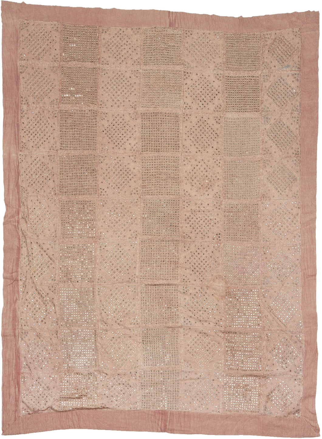 This coverlet was crafted during the 20th century in Rajasthan, India. 
It features hand cut mirrors that have been hand-stitched with silk thread into grid and diamond patterns  on cotton cloth dyed with a dusty lilac. The mirrors really sparkle in the right light.