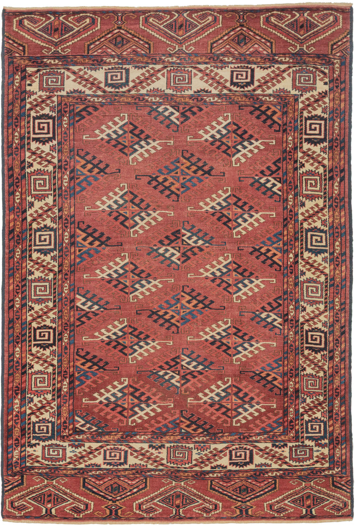 This Yomud Turkmen rug was handwoven during the early 20th century in Western Turkmenistan.
This finely balanced Yomud carpet features a repeating dyrnak-gul field in shades of plum, indigo, ivory, coral, apricot and sky blue. Each diamond-shaped motif radiates a strong tribal geometry, emblematic of Yomud weavings from the Caspian steppe.