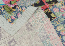 This vintage patchwork quilt was crafted in North America during the middle of the 20th century.
It features patch-worked squares of various fabric in rows of serrated stripes organized on the diagonal. Many of the squares feature there own detailed patterning which adds interest and touch of fun! Much of the stitching has been completed by hand included large visible running stitches in black giving the piece a kantha-like feel.