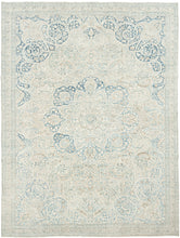 It features an elegant central medallion surrounded by flowing arabesques and floral tracery in delicate shades of sky blue, ivory, and soft taupe. The pale, airy palette and finely drawn design lend the piece a refined, almost ethereal quality that makes it versatile for both traditional and contemporary interiors. Framed by a scrolling vine border, this rug is a study in subtle sophistication and is a timeless decorative element for any space.