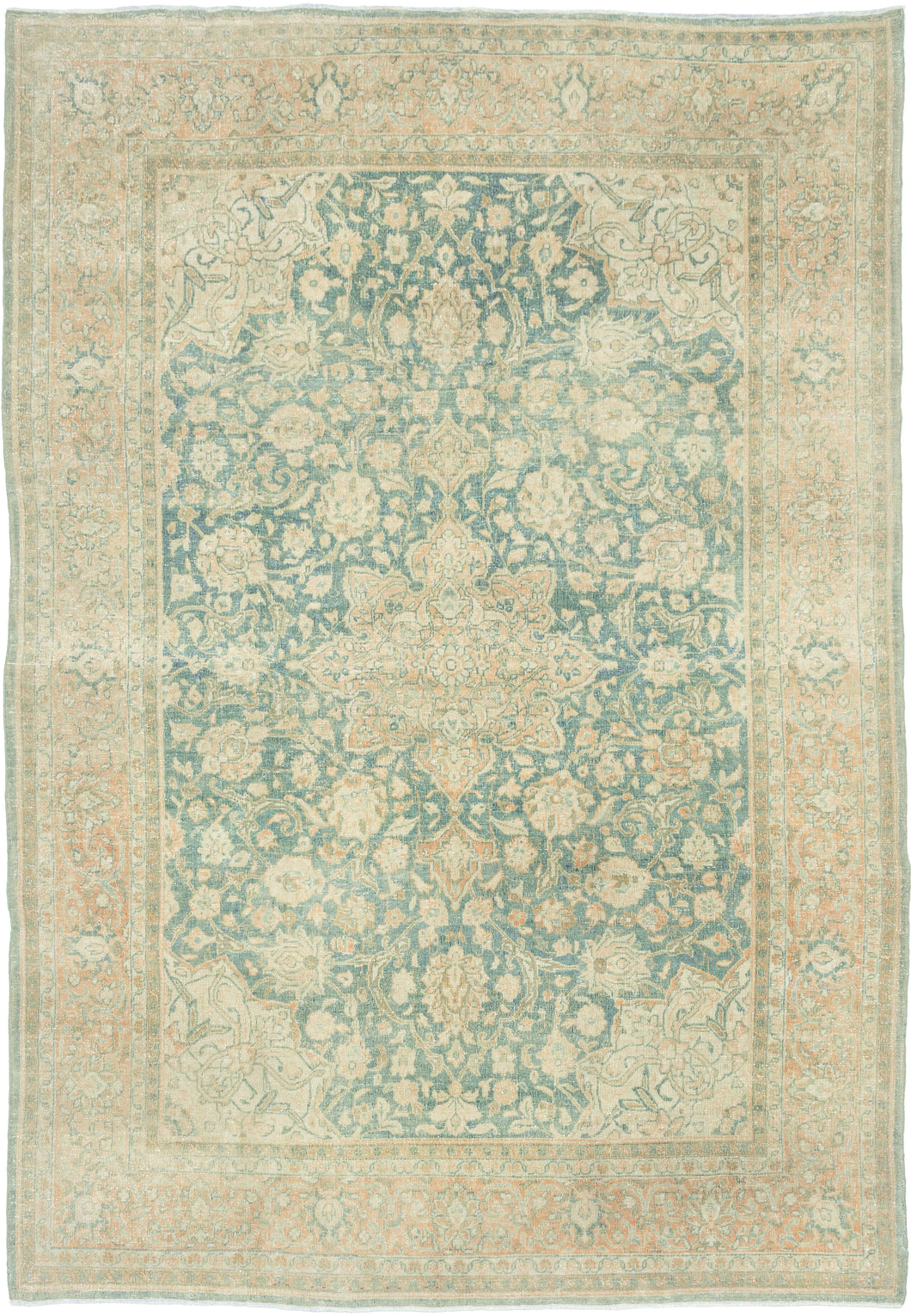 It features an ornate all-over design of muted palmettes and floral sprays in various soft shades of caramel, khaki and terracotta on an undulating indigo ground. It is framed by a border of alternating palmettes on meandering vines on a dusty peach ground. Very decorative, a soft, and elegant piece that will subtly elevate any space. washed out tabriz
