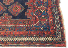 It features classic patterning associated with the Afshar people of Sirjan. In the center are two latch-hooked medallions on deep navy surrounded by a lacquer-red ground surrounded by a final field of cobalt.  Various greens, turqoise, apricot and aubergine contrast wonderfully and accentuate the various Small symbols and figures that fill the negative space. Nicely framed by an ivory main border which brightens the composition.