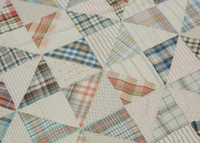 This vintage patchwork quilt was crafted in North America during the middle of the 20th century.
It features patch-worked grid composed of squares. Each square is formed of well balanced triangles of either colorful flannel patterns or more open dotted and striped cream ground patterning. The squares have been pieced together wondefully and the composition can be read many different ways that is accentuated by its perfectly square dimensions.