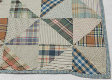 This vintage patchwork quilt was crafted in North America during the middle of the 20th century.
It features patch-worked grid composed of squares. Each square is formed of well balanced triangles of either colorful flannel patterns or more open dotted and striped cream ground patterning. The squares have been pieced together wondefully and the composition can be read many different ways that is accentuated by its perfectly square dimensions.