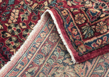 This rug features a curvilinear floral design on a red wine field. The floral work is intricate and an excellent example of the type of floral sprays Sarouk rugs are famed for. The main border features a palmette and blossom design on a navy ground. This classically patterned rug is perfect for high traffic areas and should last for generations to come. 