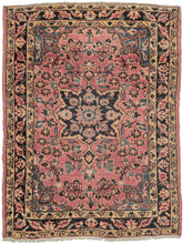 This Sarouk rug was handwoven during the second quarter of the 20th century.
It features of an deep navy central medallion on a crimson ground. The field is filled with fine floral sprays and balanced by four scalloped cornices woven in light blue. The border is composed of a straightforward floral meander in the same deep navy almost black ground of the central medallion