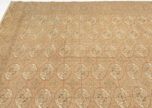 This Tekke Turkmen rug was handwoven during the second quarter of the 20th century in Turkmenistan.
The field features a grid of rounded main guls in various shades of brown, tan, bone and wheat on faded copper tone ground. The space between the grid is filled with rows of cruciform shaped secondary guls. It is encapsulated by a border of rams head filled octagons and finished with skirts of latch-hooked zigzags.