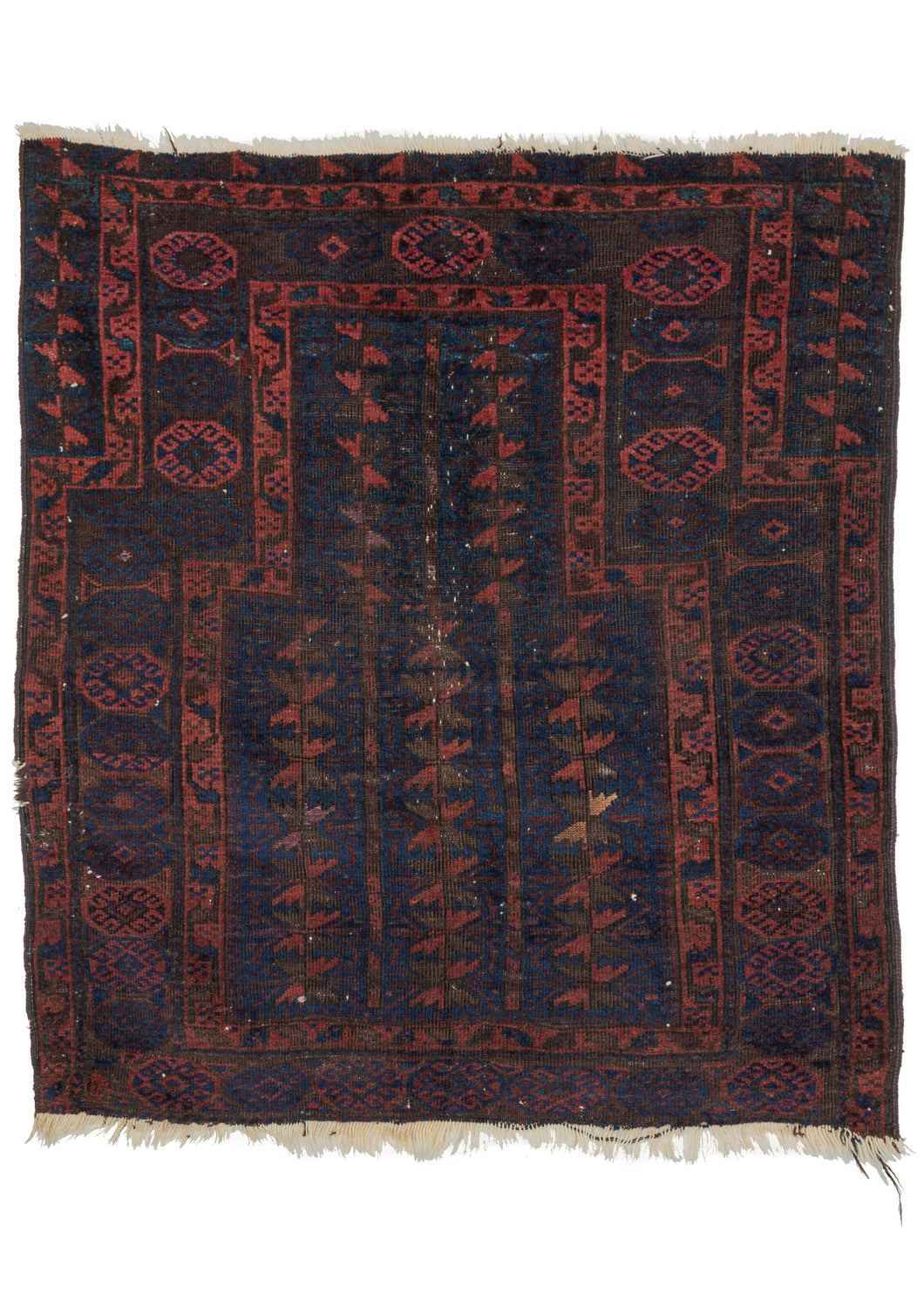 19th century Timuri Baluch rug composed of a wide prayer format often seen in early Timuri rugs. The blue ground mihrab contains a tree of life motif. Some of the serrated leaves on the tree are woven with apricot and aubergine silk. The main border is composed of hexagons with hooked geometric shapes. Outside of the small touches of colorful silk the color palette is subdued and limited to reds, blues, and oxidized browns.