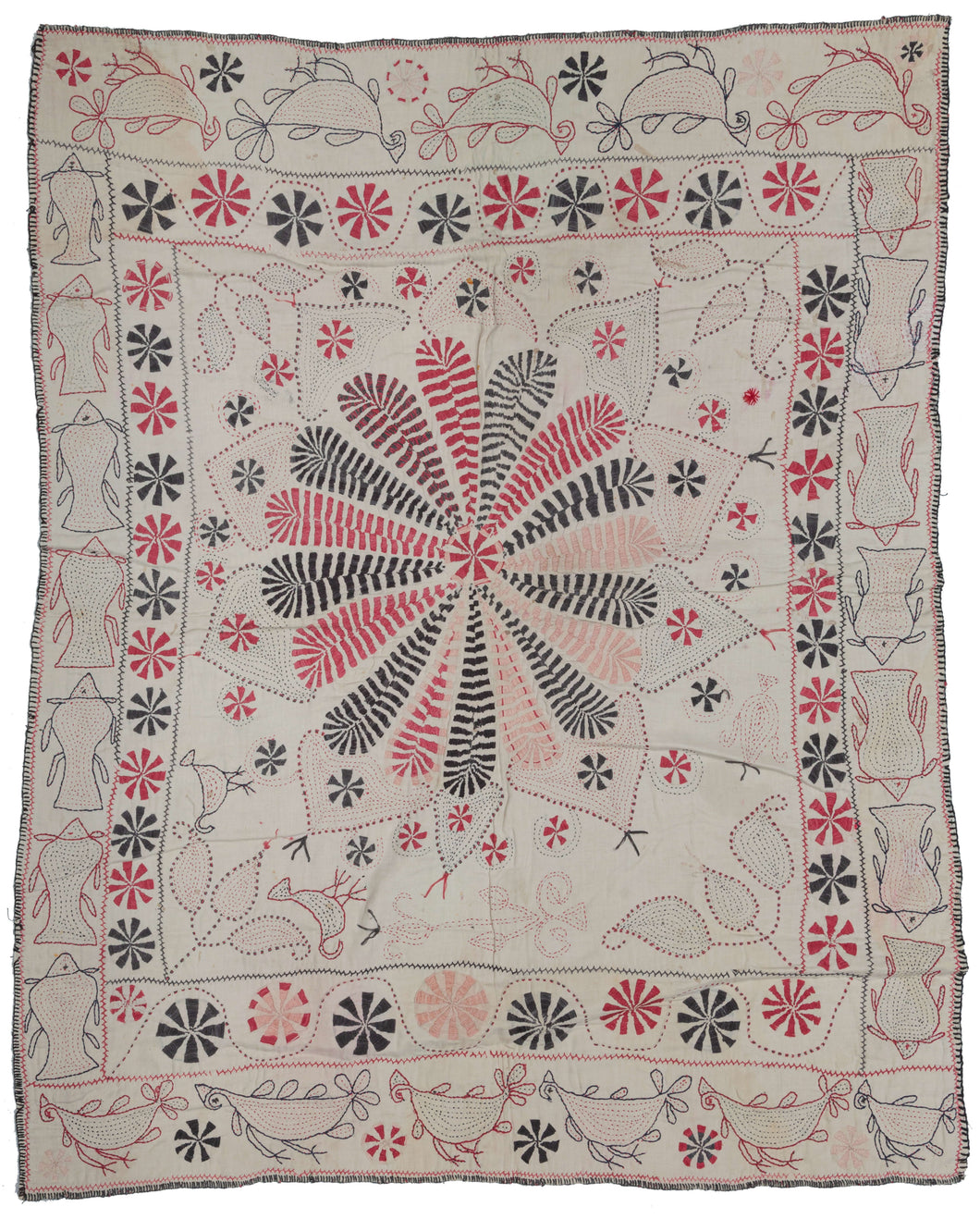 Antique Kantha featuring a central floral mandala with vegetal forms in each cornice. It has a limited palette of various red and black threads on plain white cotton ground. The red and black threads were likely harvested and reused from old clothing.  A mixed border of local fish (Ilish) on the vertical and birds (Doyel) on the horizontal frame the whole. Look closely to notice two small birds in one cornice.