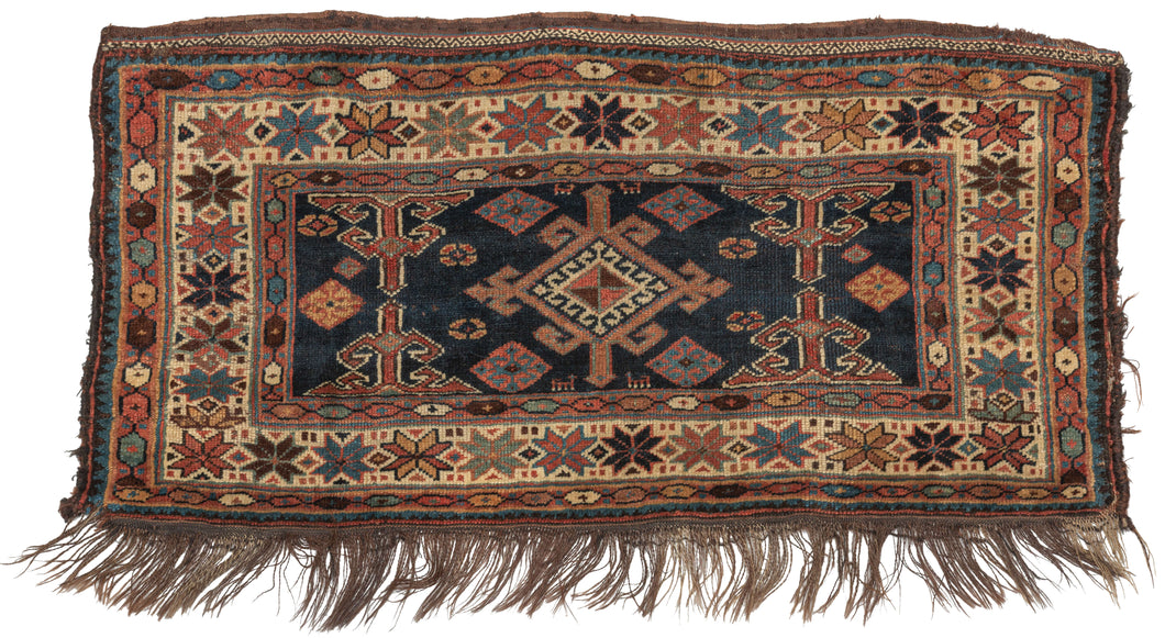 Antique Veramin bagface featuring central hooked device on a navy ground filled with various animals and protection symbols. Framed by a wide main border of multicolored eight-pointed stars on an ivory ground which is flanked by two minor borders of multicolored ovals on a soft red ground. It is finished with a slit kilim top and dotted skirt end. Nicely embellished with a salt and pepper weft float on end.