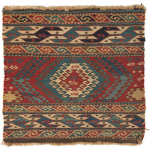 Antique Shahsavan Mafresh fragment featuring a central concentric latch hooked device in blues, green, and ivory on a red ground and flanked by strong and distinctive borders on top and bottom. Each segment features two minor borders of smooth "S" scrolls that sandwich a main border of more serpentine sawtooth "S"s. The main borders flow in opposite directions adding movement and interest.