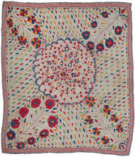 Antique Kantha featuring a detailed weblike central mandala flanked by four blossoming bouquet cornices. Each is similar yet distinctive and pokes and squishes the mandala distorting its form. The simple rendition is energized by colorful and vibrant leaf-like forms in red, blue, orange, and green cutting across the white cotton field at various angles. The whole is framed by a thin, red "chok par" or eye border.