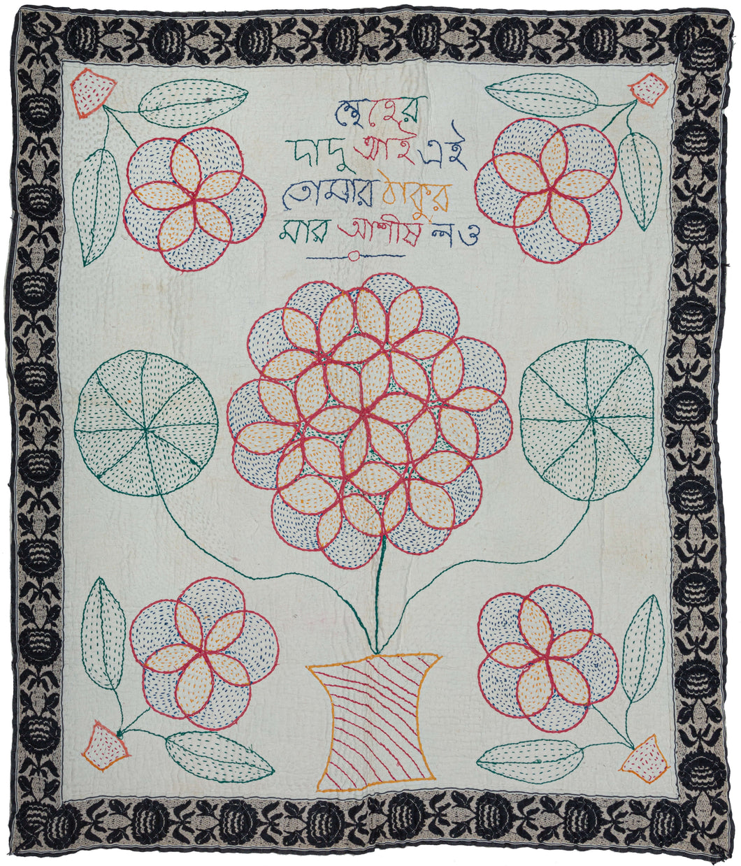 Bengali Kantha featuring a large central bouquet of flowers in a vase flanked by four smaller bouquets in vases. The leaves of the central bouquet are also interestingly rounded into pinwheel form. The outer border was taken from an old sari edge and reattached around the perimeter. The words