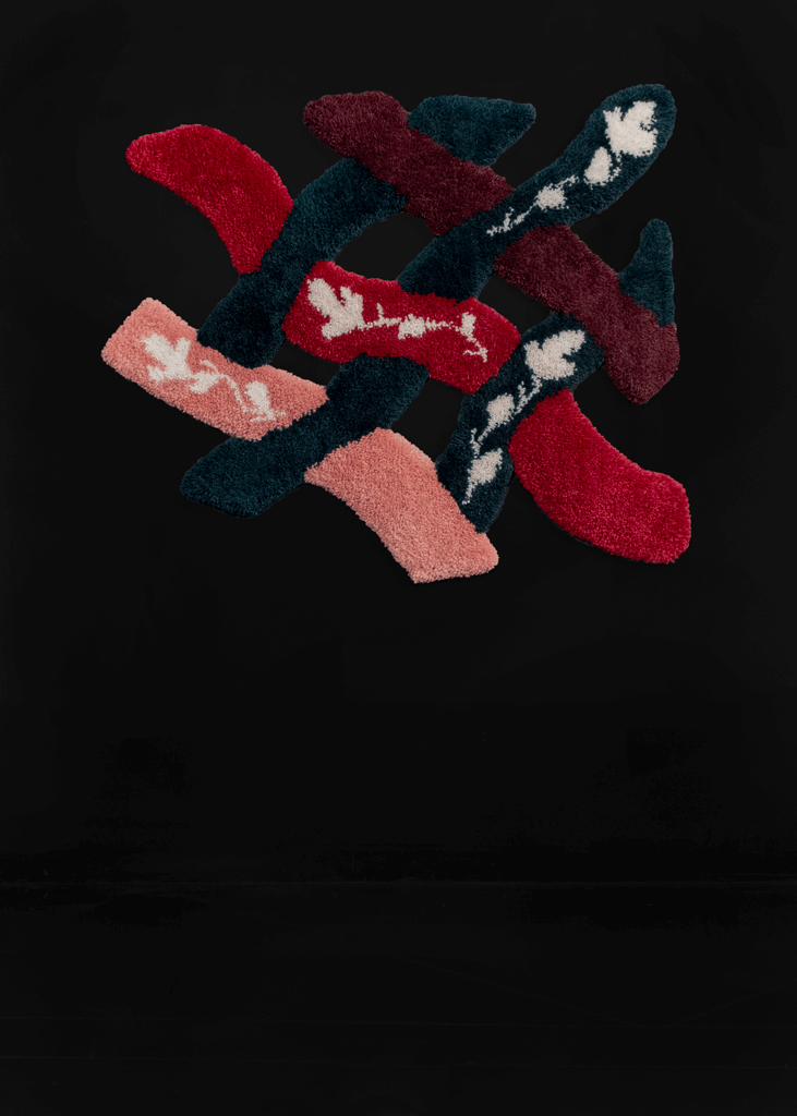 Handmade tufted rug with ivory flowers atop sections of burgundy, red, pink and teal. Zoomed in lattice design creates cut outs and irregular edges.