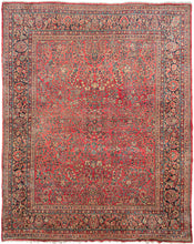 This Sarouk was handwoven in Western Iran during the second quarter of the 20th century.   This rug features a curvilinear floral design on a soft raspberry red field. The floral work is intricate and an excellent example of the type of floral sprays Sarouk rugs are known for. It features a central focal point that blends into the pattern without dominating the composition. The main border features a palmette and blossom design on a navy ground.
