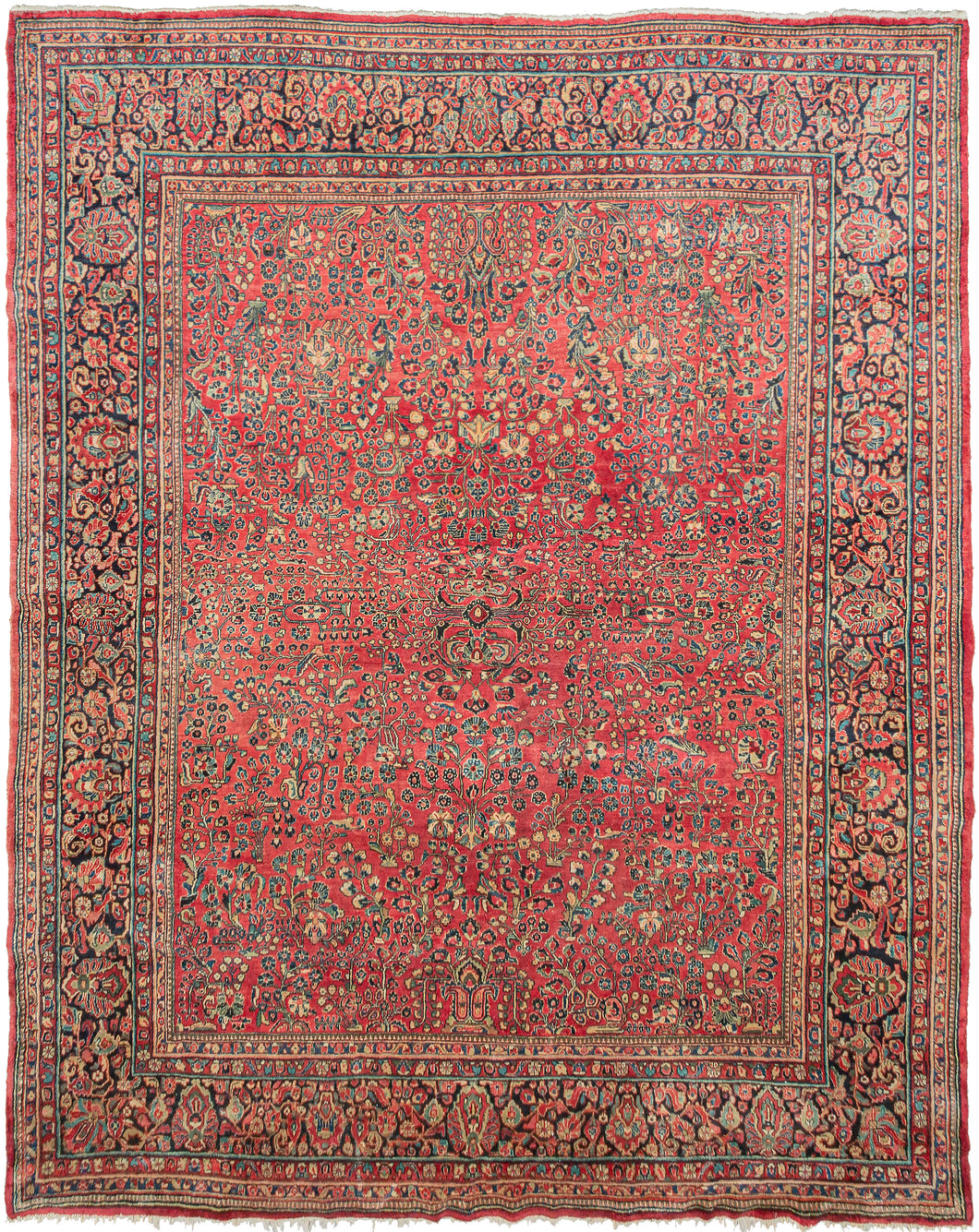 This Sarouk was handwoven in Western Iran during the second quarter of the 20th century.   This rug features a curvilinear floral design on a soft raspberry red field. The floral work is intricate and an excellent example of the type of floral sprays Sarouk rugs are known for. It features a central focal point that blends into the pattern without dominating the composition. The main border features a palmette and blossom design on a navy ground.