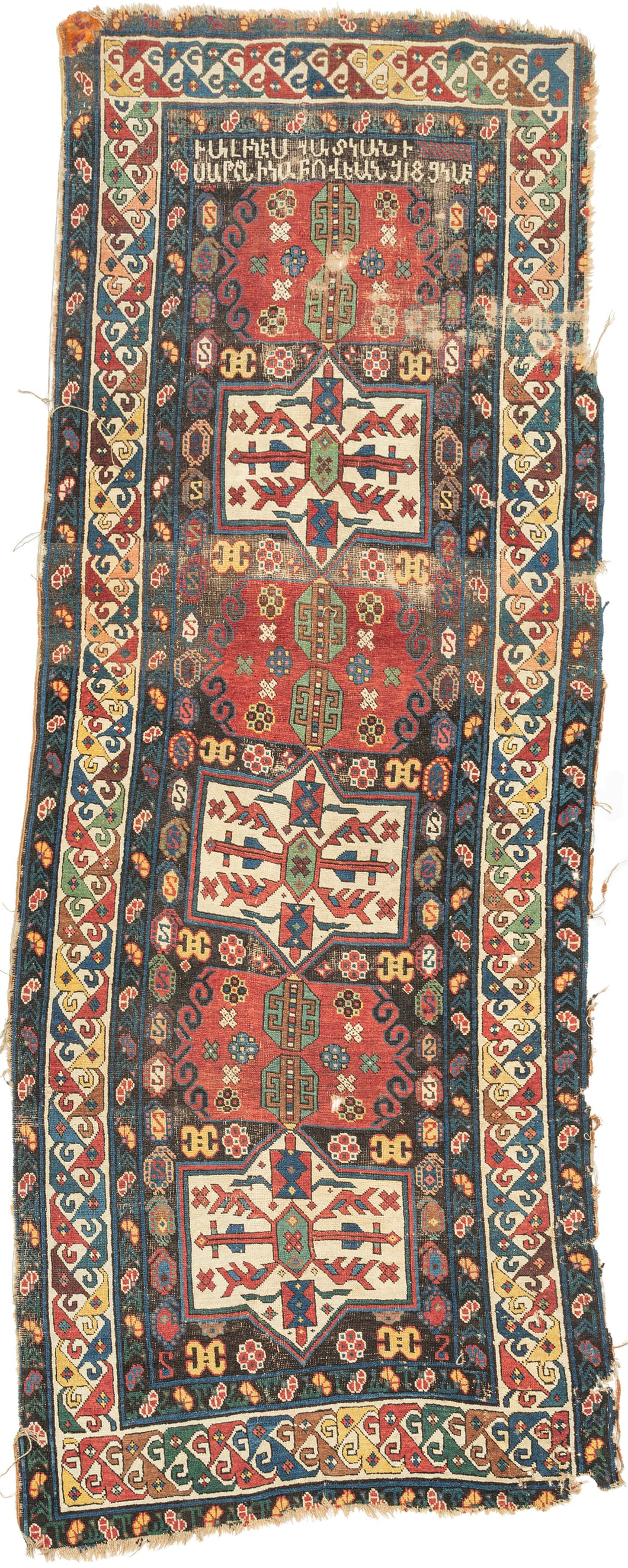 An extraordinary Armenian inscribed rug dated 1894, with a powerful sequence of geometric medallions set against a richly colored field of red, ivory, green, blue, yellow, and aubergine. The drawing is wonderfully individual, with bold hooked forms, small floral devices, and a lively multicolored border framing the composition.

Most compelling is the woven Armenian inscription, which appears to read:

“The rug of Satenik Abovian, in the year 1894.”