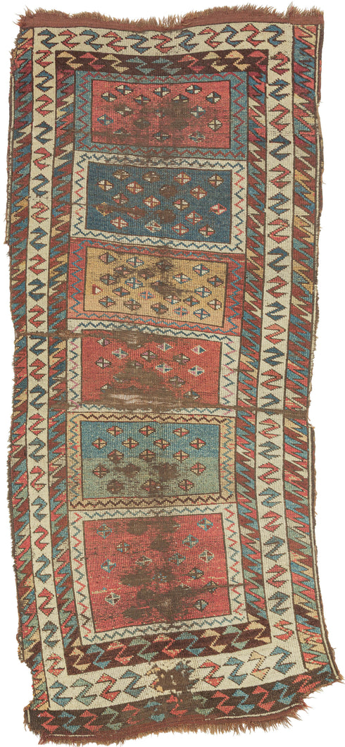 It features vertically stacked boxes, each filled with scattered diamonds across saturated grounds of color. The diamond motifs serve both as protective emblems and as a kind of visual chant, anchoring the eye while the overall composition moves with the spontaneity of Kurdish village life. The palette is classic and earthy: madder red, saffron gold, deep indigo, and teal, with ivory highlights animating the zigzag borders.