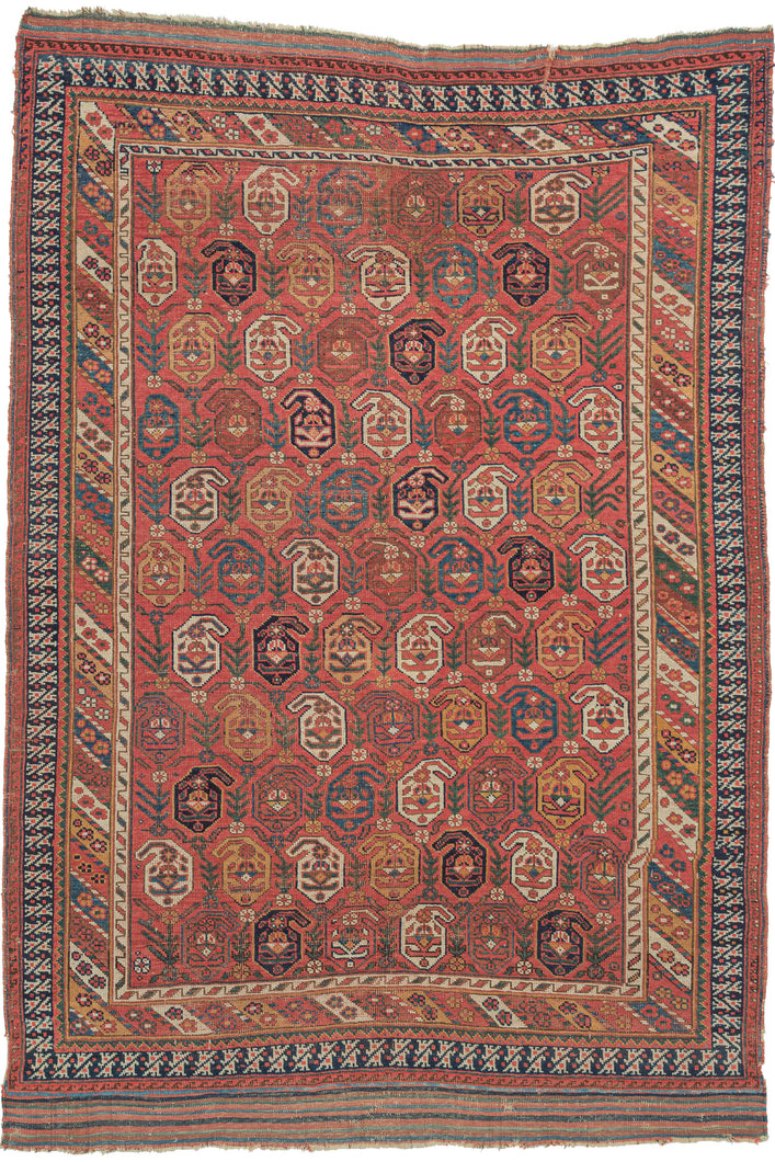 19th century It features a field of scrolling vines topped with wide blossoming botehs red, stark white, navy, indigo, and a desirable golden yellow on a red ground. It is surrounded by borders of bent ribbons, diagonal stripes and most prominently a dinosaur-like primitive bird border. This group of Afshars is thought to be woven in the Aqta region and have taken their patterning from nearby Kerman shawls. Nicely finished with striped kilim skirt borders on the top and bottom.