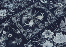A striking Miao batik wall hanging or coverlet on a deep indigo ground, densely animated with birds, butterflies, fish, flowers, and curling vines in white wax resist. The imagery draws on a rich symbolic vocabulary associated with the natural world, fertility, abundance, renewal, and continuity.