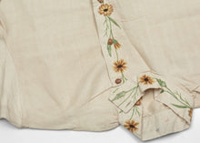 This elegant vintage Indian Kurta is crafted from soft, handwoven cotton in a natural cream tone, delicately embroidered with wildflower motifs in warm golden, green, and earthy brown tones. The floral embellishment flows organically along the hem, cuffs, and front placket, offering a refined yet joyful expression of traditional artistry.
