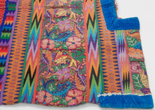 This spectacular Huipil is alive with symbolism and saturated color. The brocaded upper panel features a lush tableau of birds, flowers, and brilliantly woven fish, each motif carrying deep resonance in Maya tradition. Birds evoke freedom and the sky, flowers embody fertility and beauty, and fish symbolize life’s connection to water and abundance.

