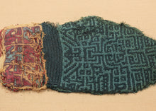 This Pre-Columbian textile fragment dates to the Wari period (circa 600–1000 AD) and is believed to be a panel from an elite tunic, serving as a form of rank insignia.

The design features a bold, labyrinthine geometric motif in tone on tone indigo and turqoise offset by remnants of a multicolor section in cochineal red, gold, and turquoise. These complex patterns are emblematic of Wari statecraft, where textiles conveyed status, authority, and identity.&nbsp;Technically, this piece exemplifies the Wari mas