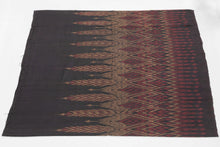 This elegant silk pha sin or traditional tube skirt was handmade northeast Thailand during the middle of the 20th century.

It is a masterful example of mudmee (ikat) weaving from the Isaan region.&nbsp;The central field (phuen sinh) displays alternating vertical bands of nested diamonds and stylized rice ear or flame motifs that are elongated and tapered into arrow forms that symbolize fertility, protection, and spiritual aspiration in regional Lao-Tai iconography.

The top band (hua sinh) offers a rhythm 