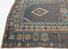 This rug was likely woven likely in the Hakkari - Rawanduz corridor of the Kurdish Highlands of Iraq during the turn of the 20th century

This deeply expressive Kurdish village rug presents a masterclass in tribal geometry, color harmony, and cultural symbolism. It features a field anchored by two nested diamond medallions, each filled with small, rhythmic glyph-like motifs and set against a ground of saturated indigo blue and madder red abrashed into glowing mineral shades. Surrounding the central field ar