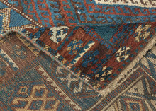 This rug was likely woven likely in the Hakkari - Rawanduz corridor of the Kurdish Highlands of Iraq during the turn of the 20th century

This deeply expressive Kurdish village rug presents a masterclass in tribal geometry, color harmony, and cultural symbolism. It features a field anchored by two nested diamond medallions, each filled with small, rhythmic glyph-like motifs and set against a ground of saturated indigo blue and madder red abrashed into glowing mineral shades. Surrounding the central field ar