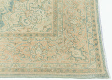 It features an ornate all-over design of muted palmettes and floral sprays in various soft shades of caramel, khaki and terracotta on an undulating indigo ground. It is framed by a border of alternating palmettes on meandering vines on a dusty peach ground. Very decorative, a soft, and elegant piece that will subtly elevate any space. washed out tabriz