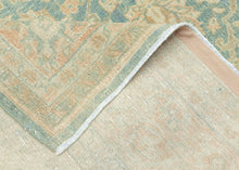 It features an ornate all-over design of muted palmettes and floral sprays in various soft shades of caramel, khaki and terracotta on an undulating indigo ground. It is framed by a border of alternating palmettes on meandering vines on a dusty peach ground. Very decorative, a soft, and elegant piece that will subtly elevate any space. washed out tabriz
