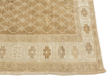 KURD Its warm camel field is animated by a playfully wonky interlocking lattice and framed by a border of larger floral medallions in soft ivory and beige. The lattice has the feel of a bent and distorted chain link fence. The delightful irregularity in the design has an endearing quality that speaks to its handmade nature and gives the piece a unique, almost whimsical character. The washed out neutral palette and subtle abrash create a natural warmth, making it a versatile choice for both traditional and c