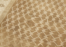 KURD Its warm camel field is animated by a playfully wonky interlocking lattice and framed by a border of larger floral medallions in soft ivory and beige. The lattice has the feel of a bent and distorted chain link fence. The delightful irregularity in the design has an endearing quality that speaks to its handmade nature and gives the piece a unique, almost whimsical character. The washed out neutral palette and subtle abrash create a natural warmth, making it a versatile choice for both traditional and c