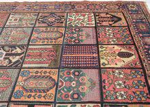 A dazzling mosaic of color and pattern, this Bakhtiari garden carpet embodies one of the most celebrated designs in Bakhtiari weaving. The field is laid out in a grid of rectangular compartments, each filled with distinctive vignettes of stylized floral sprays, trees of life, geometric abstractions, and architectural motifs. The diversity within each panel creates a captivating patchwork, at once orderly and exuberant. Lively tones of coral, madder red, indigo, sky blue, ivory, and soft green animate the de