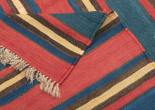 A striking example of simplicity elevated to art, this antique Shahsavan kilim reveals the timeless sophistication of stripe-based design. Its alternating bands of madder red, indigo blue, golden ochre, and earthy brown create a bold yet harmonious rhythm across the surface. The restrained palette and unbroken horizontality give the piece a modernist clarity that feels as relevant today as it did over a century ago.