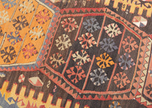 This kilim was handwoven in the Malatalya region of Eastern Anatolian during the early 20th century.

It features a horizontal row of four multi-lobed medallions, each filled with stylized floral motifs. The medallions float on a deep walnut-brown ground, offset by aubergine, apricot, saffron yellow, indigo, soft blues, and madder tones. The surrounding borders alternate hooked amulet forms and diamond devices, creating a rhythmic frame around the central axis.